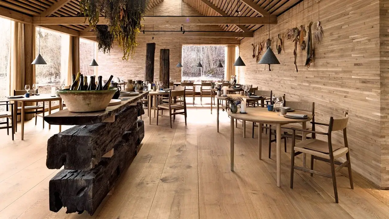 Minimalist Nordic dining table set with natural wood plates and handcrafted ceramic bowls in Fjeld's dining room